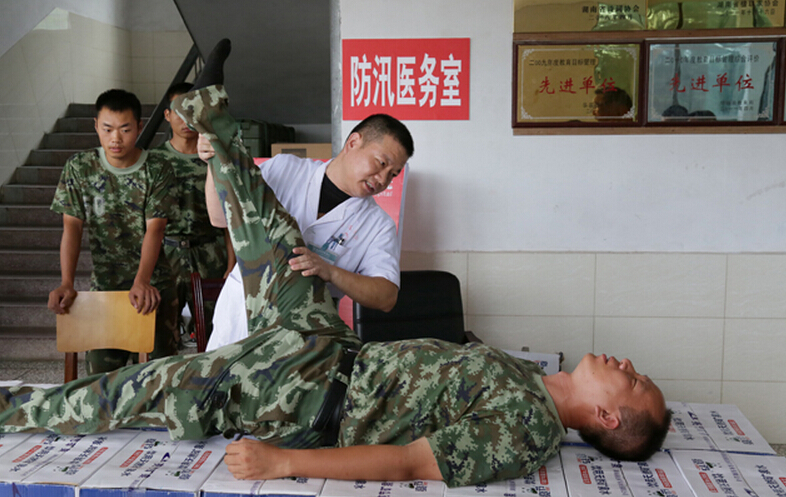 圖為醫(yī)療隊醫(yī)生在為8730部隊武警抗洪部隊官兵進(jìn)行中醫(yī)正骨治療。